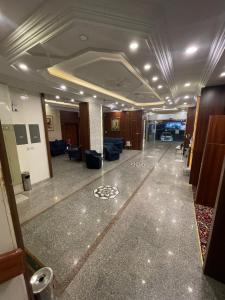 an office lobby with a hallway with couches and chairs at Relax Day Hotel in Tabuk