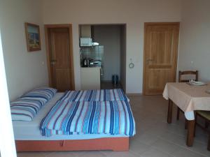 a bed in a room with a table and a kitchen at Apartments Delfini in Sveti Filip i Jakov