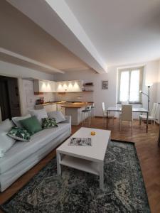 ein Wohnzimmer mit einem weißen Sofa und einem Tisch in der Unterkunft Parma Central Apartments in Parma