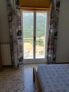 een slaapkamer met een bed en een groot raam bij Guado di Pio-appartamento panoramico in Castelpetroso