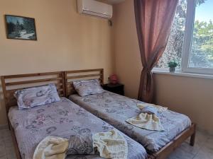 two twin beds in a room with a window at Guest House 51 in Kranevo +143 photos
