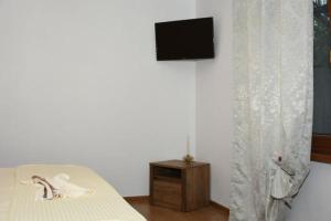 a bedroom with a bed and a television on a wall at CASA DIN SAT in Eşelniţa
