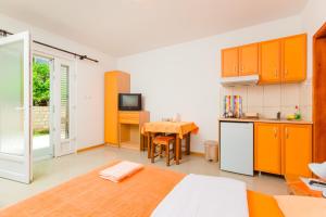 Habitación con cama y cocina con mesa en Rosić Apartments, en Tivat