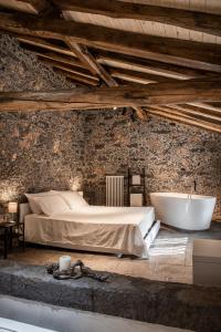 Schlafzimmer mit einem Bett und einer Badewanne in der Unterkunft Casa Cavagrande in Fornazzo