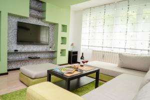 uma sala de estar com um sofá e uma televisão em Bright 1BDR Apartment in the City Center em Sarajevo