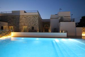 a villa with a swimming pool in front of a house at Dimora Le Site in Torre Suda