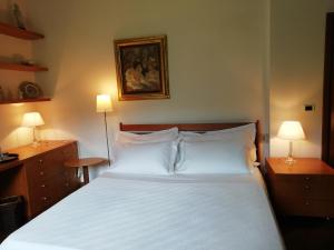 a bedroom with a white bed and two lamps at Villa le Noci in Bettola +46 photos