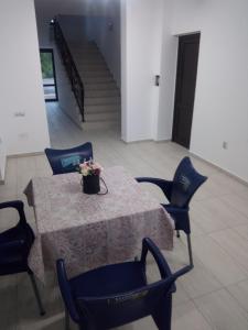 a table with chairs and a vase of flowers on it at Pensiunea Valea Beiului in Socolari