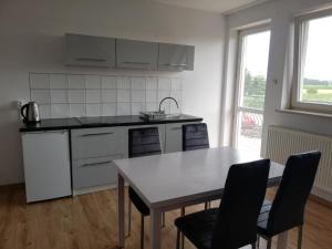 a kitchen with a table and a table and chairs at Wieża nad Biebrzą in Dolistowo