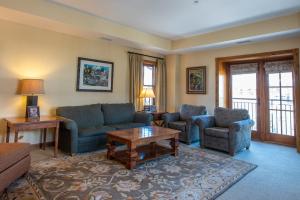 a living room with a couch and chairs and a table at Two Bedroom Condo with Balcony over Mountaineer Square - Just Steps from the Slopes! condo in Crested Butte