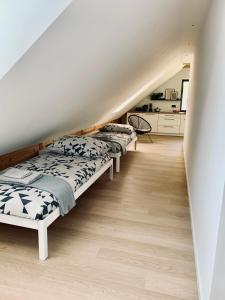 a row of beds in a room with a staircase at Apartamenty KAHOY balia pomost Kozin in Kozin