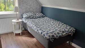 uma pequena cama num quarto com uma parede azul em Nytorpsgården em Arbrå