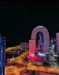 een nachtzicht op een groot gebouw in een stad bij Black Sea Vi Dari Apartments in Batoemi