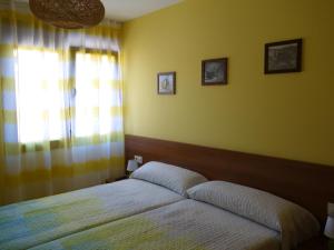 um quarto com uma cama e uma janela em Casa Rural Maruja 