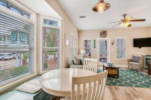 a living room with a table and chairs and windows at Redfish Cottage in Santa Rosa Beach