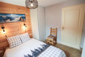 1 dormitorio con 1 cama y pared de madera en L'Alpin- Appartement 2ch au pied des pistes- tarif lits faits et linge de toilette compris en Aussois