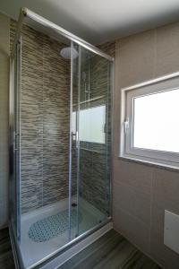 a glass shower in a bathroom with a window at Casa do Beco - Fabulous 3 Bedroom House with an Office, Seia, Serra da Estrela in Lapa dos Dinheiros