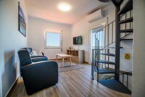 a living room with a staircase and a chair at Casa do Beco - Fabulous 3 Bedroom House with an Office, Seia, Serra da Estrela in Lapa dos Dinheiros
