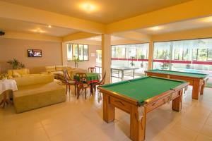 ein Wohnzimmer mit einem Billardtisch und einer Tischtennisplatte in der Unterkunft Morro do Sol Hotel & Eventos in Porto Belo