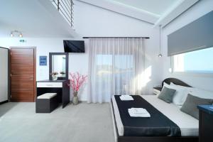 a bedroom with a bed and a desk and a television at Onar in Skala Marion