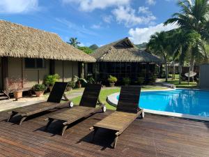 a group of chairs sitting next to a swimming pool at Muri Beach Hideaway - Adults Only in Rarotonga