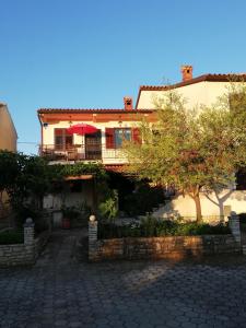 a house with a patio and a tree in front of it at Apartment Stella in Vodnjan