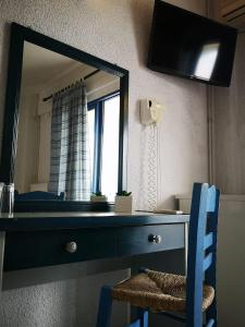 a mirror on a dresser with a blue chair in a room at PIERIA MARE in Paralia Katerinis