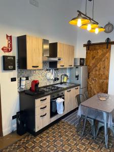 een keuken met een fornuis, een koelkast en een tafel bij TheRoom in Catania
