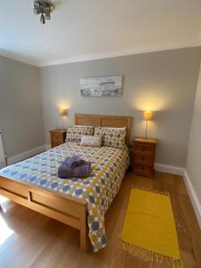 1 dormitorio con 1 cama y 2 mesitas de noche con lámparas en Sandown Seaside Apartment Ground Floor 4, en Sandown