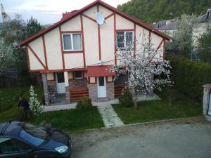 a house with a car parked in front of it at Zelena Sadyba Bila Stavka in Yaremche