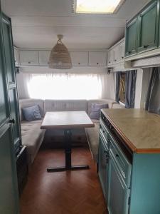 a small kitchen with a table in a trailer at Camping Farm in Karczów