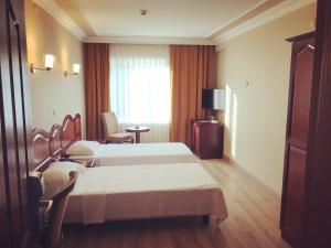 a hotel room with two beds and a window at Grand Hotel Seferoğlu in Istanbul