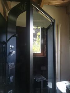 a glass shower door in a room with a window at Camping Farm in Karczów