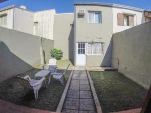 un patio con 2 sedie e un tavolo di fronte a un edificio di Casa Dúplex en Cataratas del Iguazú a Puerto Iguazú