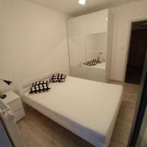 ein weißes Bett in einem Zimmer mit Spiegel in der Unterkunft Apartament Ruczaj 2 in Lublin