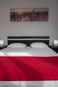 a bed with a red blanket on top of it at Apartamentos Portodouro - Ribeira in Porto