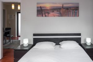 a bedroom with a large white bed with two lamps at Apartamentos Portodouro - Ribeira in Porto