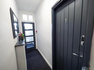 korytarz z czarnymi drzwiami i lustrem w obiekcie Sea View House w Scarborough