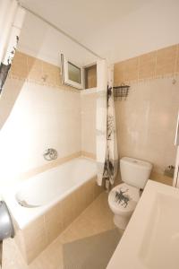 a bathroom with a tub and a toilet and a sink at Annas & Konstantinos Home in Neoi Epivates