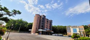 un edificio de ladrillo alto con un estacionamiento delante de él en Hotel The Star en Yeonggwang