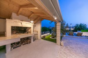 einen Wohnbereich im Freien mit einem Kamin und einer Terrasse in der Unterkunft Villa Pescatore in Trogir