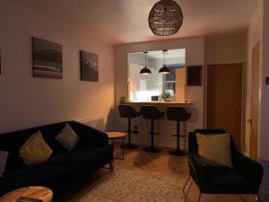 a living room with a couch and chairs and a kitchen at Skippers Retreat (with free doorstep parking) in North Berwick