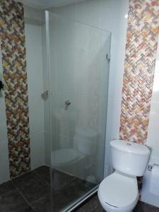 a bathroom with a toilet and a glass shower at Ocean blue Ed Conquistador in Cartagena de Indias