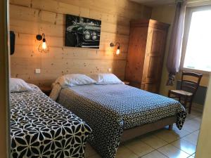 a bedroom with two beds and a camera on the wall at Abel Hôtel in Langeac