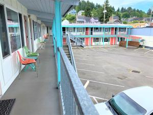 a balcony of a building with chairs and a parking lot at Atomic Motel in Astoria, Oregon