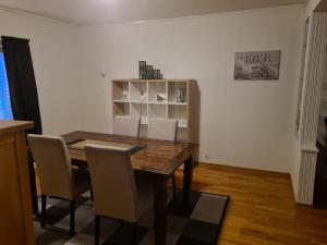 a dining room with a wooden table and chairs at Festningsgaten Apartement in Vardø