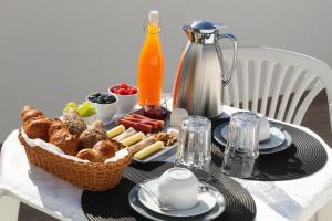 una mesa de desayuno con una cesta de pan y fruta en Alojarte, en Figueiros