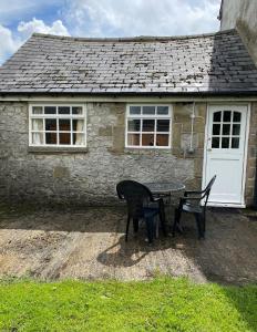 a table and two chairs in front of a building at Staden Grange in Buxton