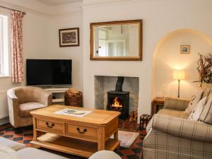 a living room with a fireplace and a television at Bridge View Cottage in Telford