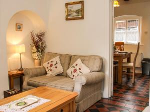 uma sala de estar com um sofá e uma mesa em Bridge View Cottage em Telford